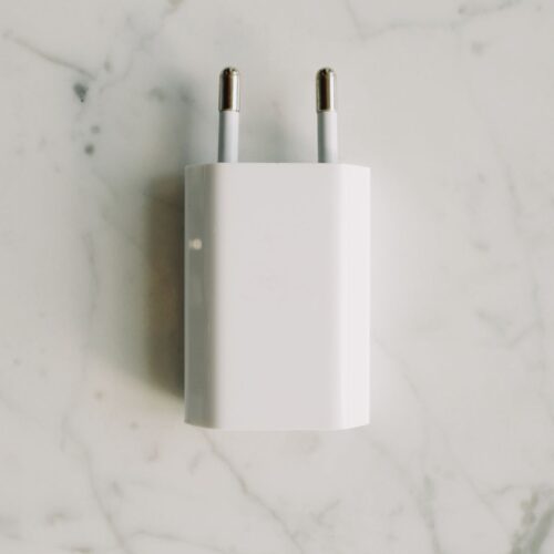 Adaptateur secteur blanc : photo illustrative Pexels Adaptateur secteur blanc sur une surface en marbre, photo illustrative